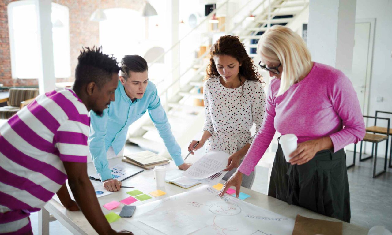 A group UX designers and researchers in an office space collaborating on a project together.