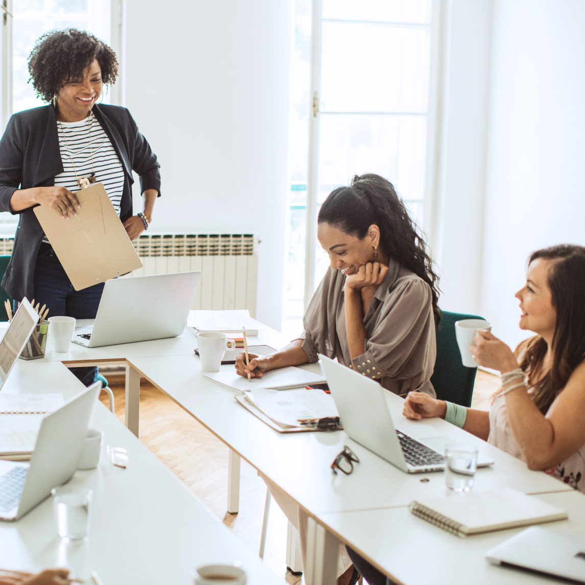 women in conference room smiling and laughing