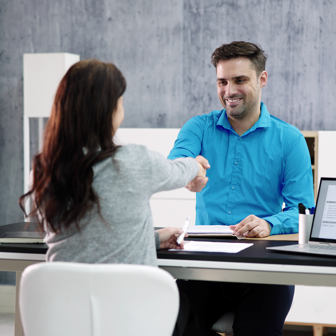 man and women shaking hands across desk
