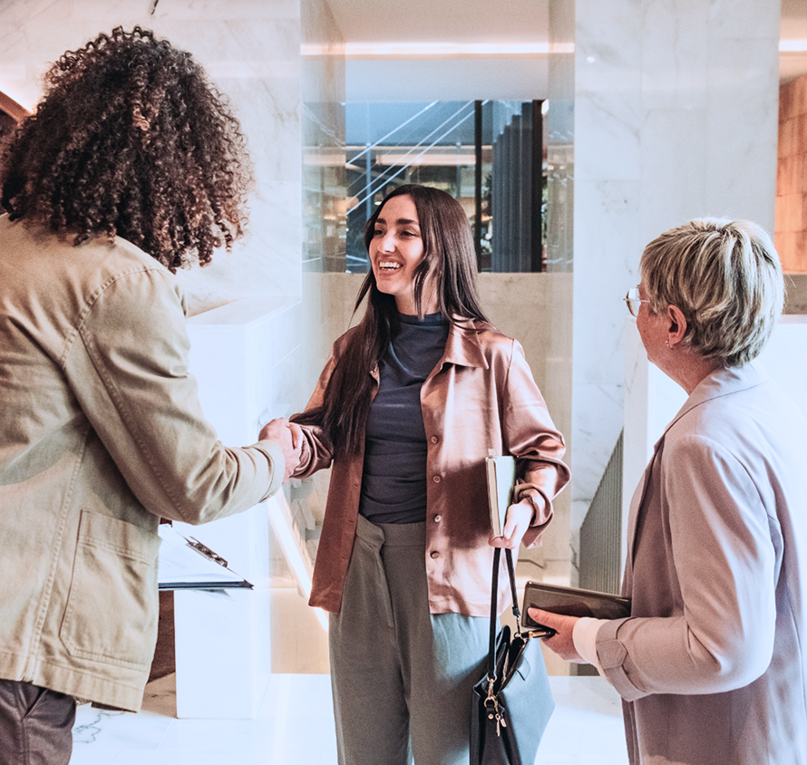 women shaking hands in office
